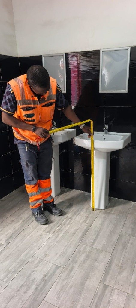 M. Ibrahim Atama prenant des mesures précises sur un chantier de lavabos